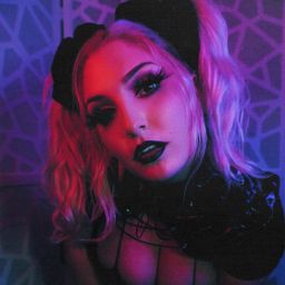 Matriarch Malice posing for the camera in leather and straps.